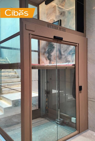 Easy to use Cibes glass home lift beside a marble staircase.