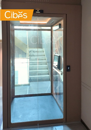 Residential homelift installed in modern villa interior beside staircase.