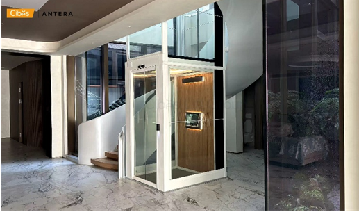 Screw driven home elevator with glass panels in a modern house.